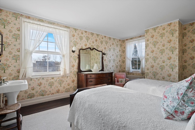 bedroom with radiator heating unit and dark hardwood / wood-style flooring