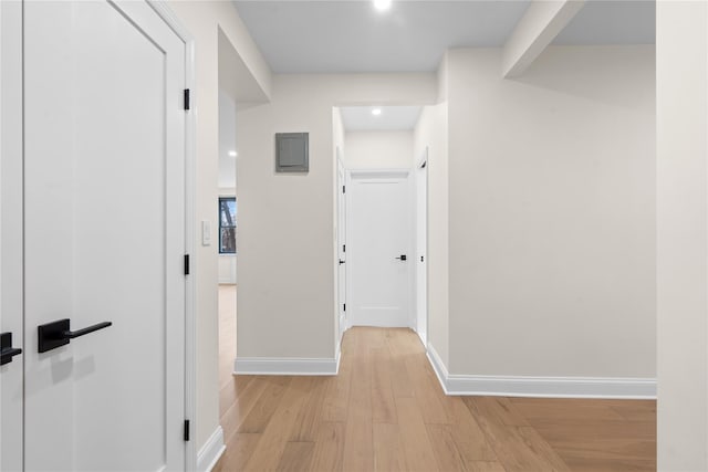 hall with light hardwood / wood-style floors and electric panel