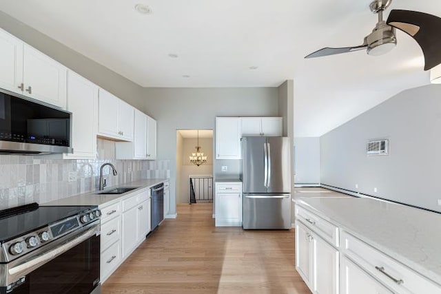 kitchen with white cabinetry, appliances with stainless steel finishes, light hardwood / wood-style floors, and backsplash