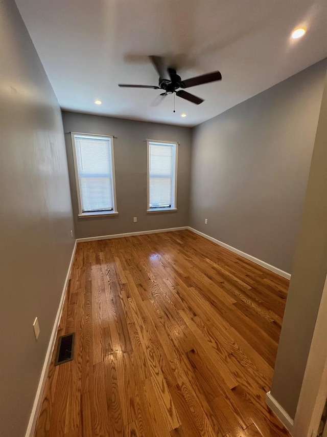 empty room with ceiling fan and light wood-type flooring