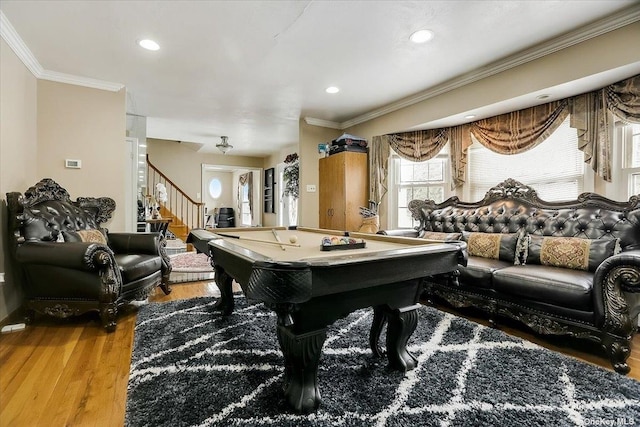 recreation room featuring ornamental molding and hardwood / wood-style floors