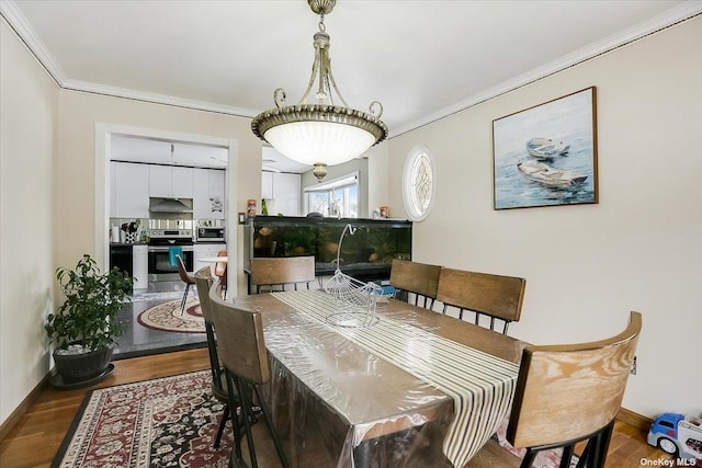 dining space with hardwood / wood-style flooring and ornamental molding