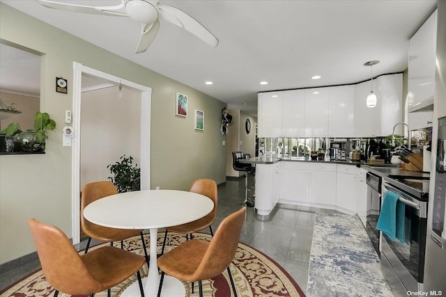 kitchen with hanging light fixtures, stainless steel electric range, white cabinets, and ceiling fan