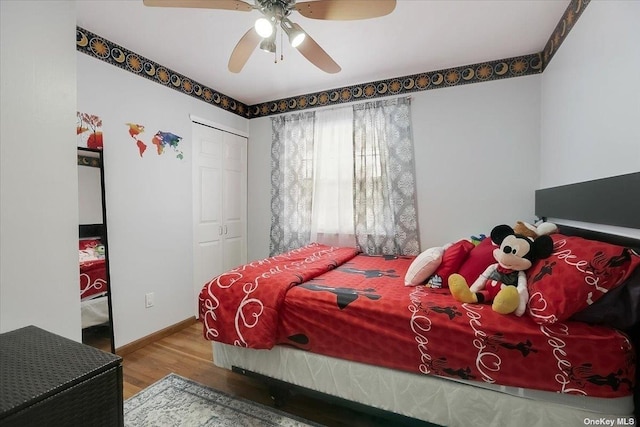 bedroom with hardwood / wood-style flooring, ceiling fan, and a closet