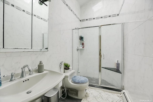 bathroom with sink, tile walls, walk in shower, baseboard heating, and toilet