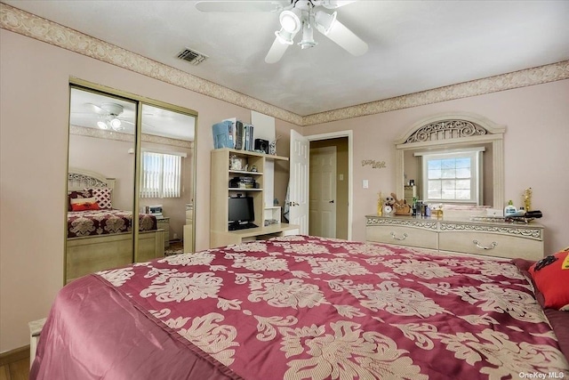 bedroom with multiple windows, ceiling fan, and a closet