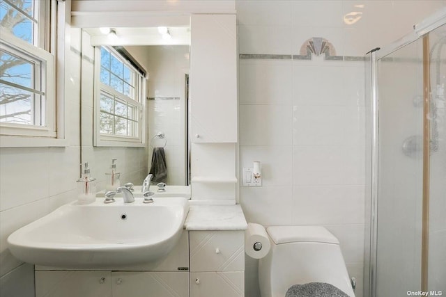 bathroom featuring tile walls, vanity, toilet, and walk in shower