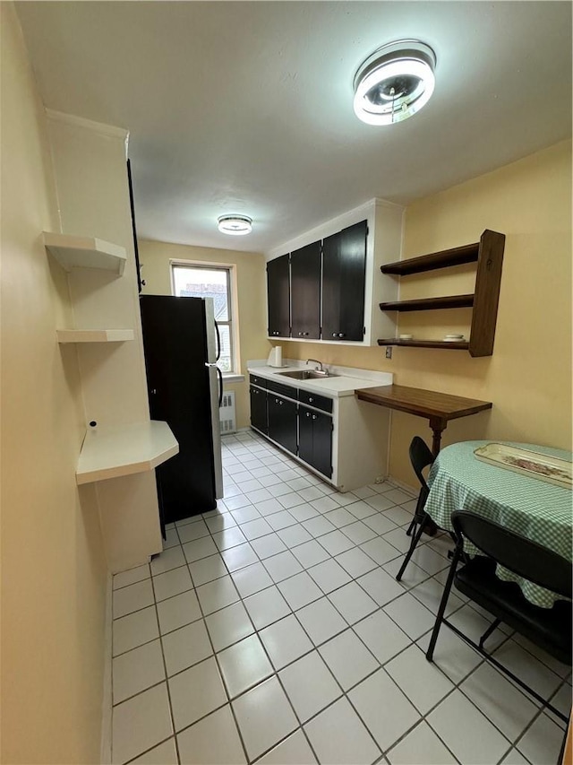 kitchen with sink, light tile patterned floors, and stainless steel fridge