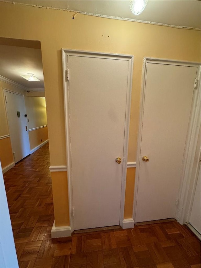 corridor featuring crown molding and dark parquet flooring