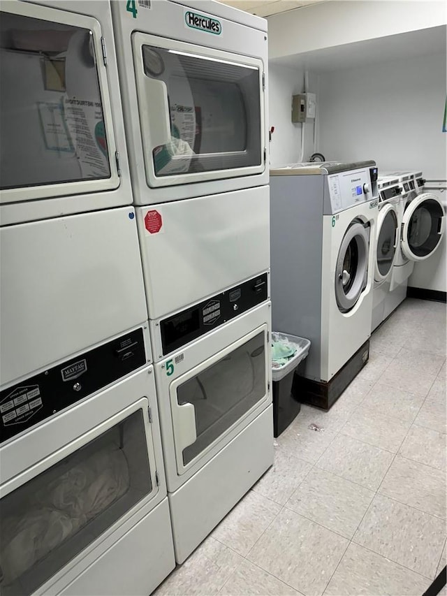 clothes washing area with stacked washing maching and dryer and washer and clothes dryer