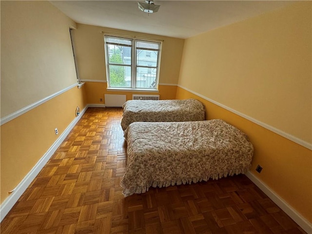 bedroom featuring radiator heating unit and parquet floors