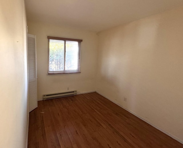 empty room with a baseboard radiator and dark hardwood / wood-style flooring