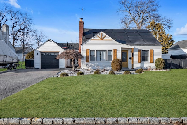 view of front of house with a garage, a front yard, and solar panels