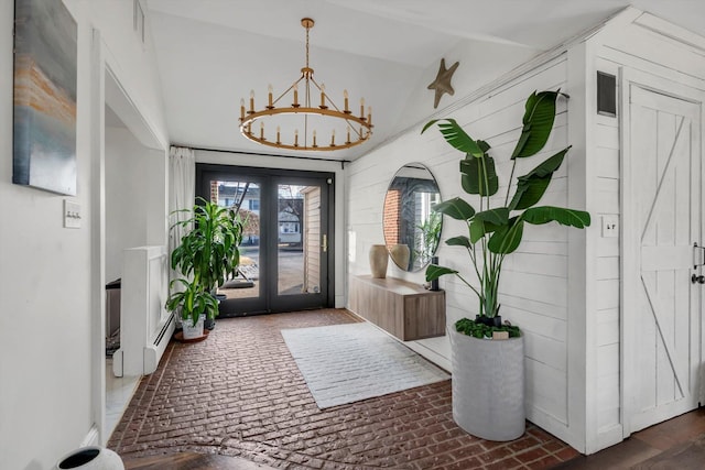 entrance foyer with a baseboard heating unit, a notable chandelier, and french doors