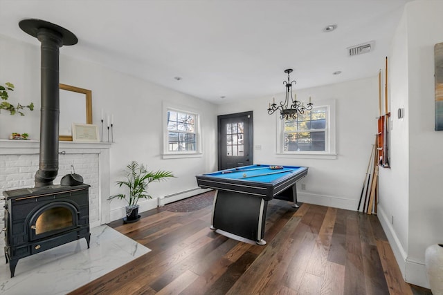 playroom featuring billiards, a baseboard heating unit, dark hardwood / wood-style flooring, and a wood stove