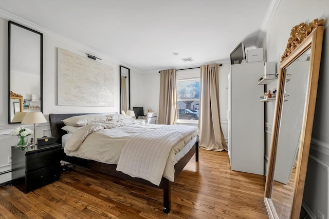 bedroom with ornamental molding and wood-type flooring