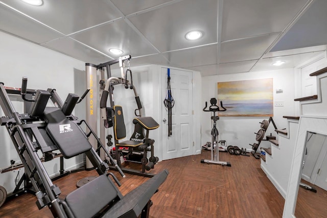 exercise area with dark hardwood / wood-style flooring and a drop ceiling