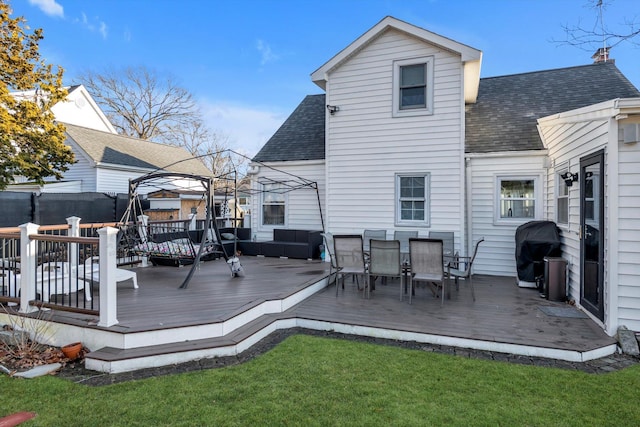 rear view of property with a gazebo, a yard, and a deck