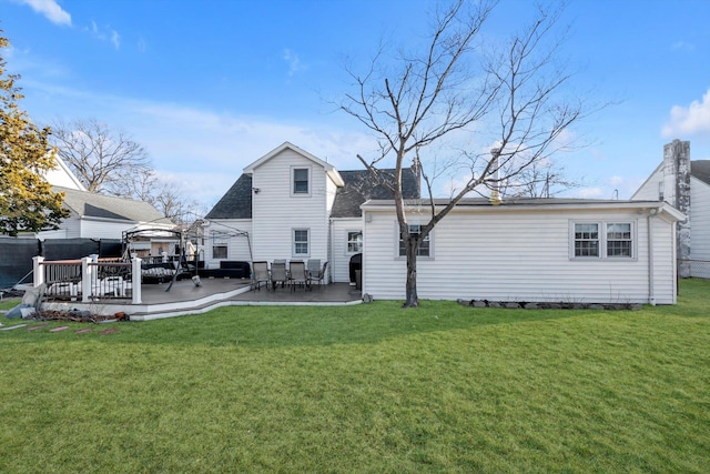 rear view of property with a gazebo, a wooden deck, and a lawn