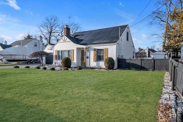 view of front of property with a front lawn and solar panels