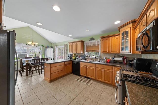 kitchen with sink, vaulted ceiling, pendant lighting, stainless steel appliances, and backsplash