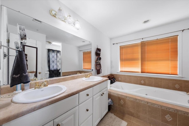 bathroom featuring vanity and tiled bath