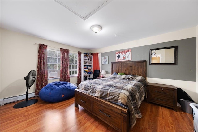 bedroom featuring hardwood / wood-style floors, baseboard heating, and cooling unit