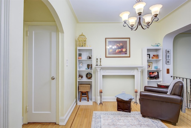 sitting room featuring a chandelier and light wood-type flooring