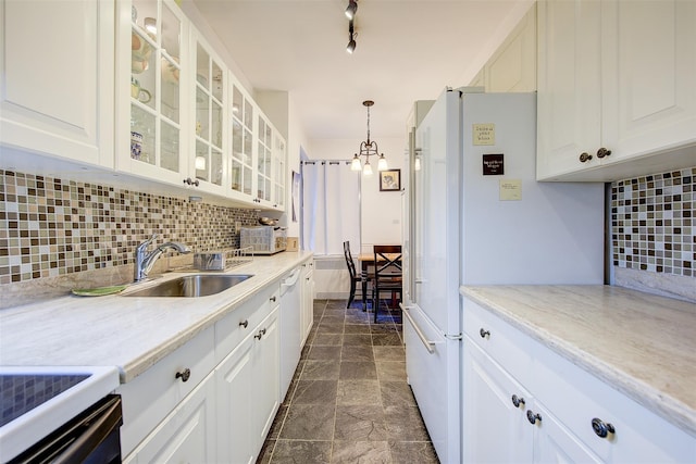 kitchen with pendant lighting, white cabinetry, sink, decorative backsplash, and light stone counters