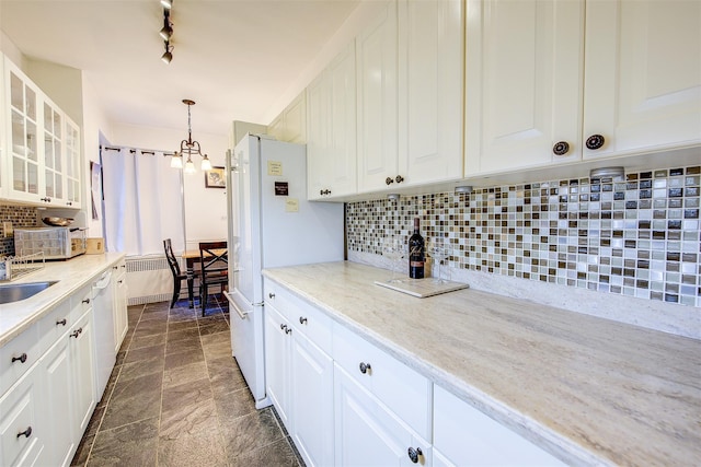 kitchen featuring white cabinetry, hanging light fixtures, light stone countertops, decorative backsplash, and a chandelier