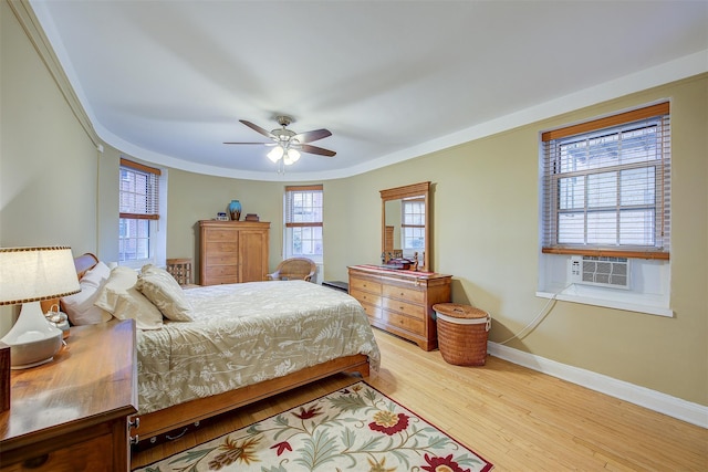 bedroom with cooling unit, crown molding, ceiling fan, and light wood-type flooring