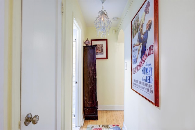 hall featuring a notable chandelier and light hardwood / wood-style floors