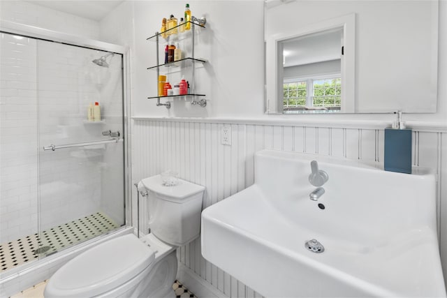 bathroom with walk in shower, sink, and toilet