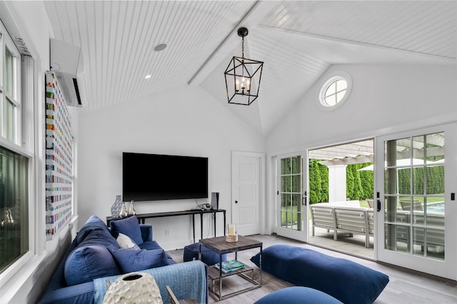 living room featuring an inviting chandelier, a wealth of natural light, high vaulted ceiling, and light wood-type flooring