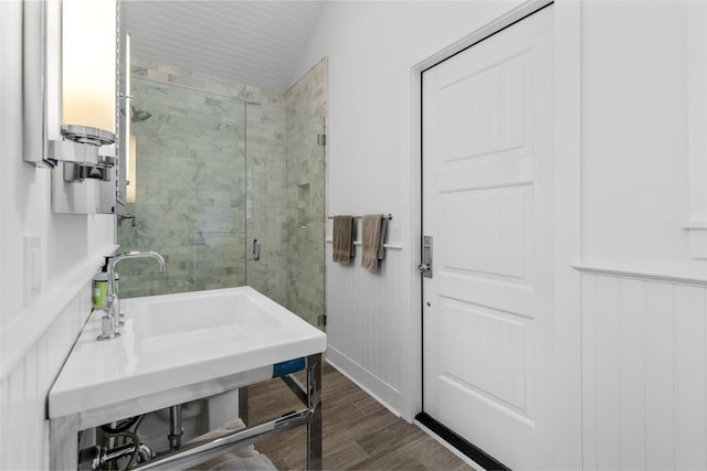 bathroom with an enclosed shower, hardwood / wood-style flooring, and vaulted ceiling