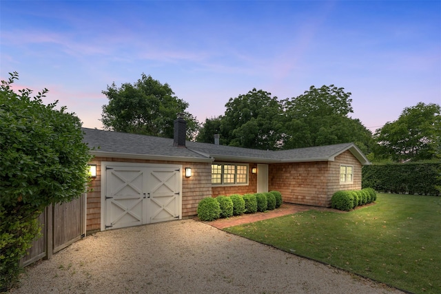 view of front of house featuring a garage and a yard