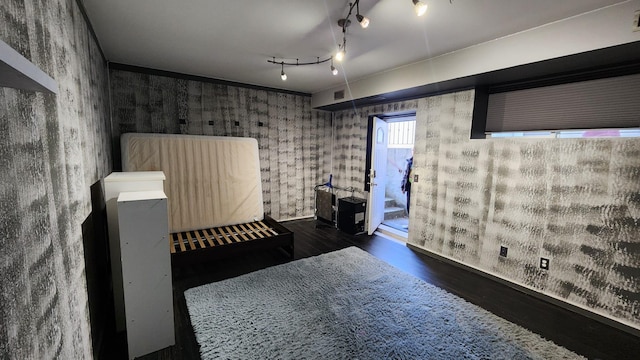 bedroom featuring track lighting and dark hardwood / wood-style flooring