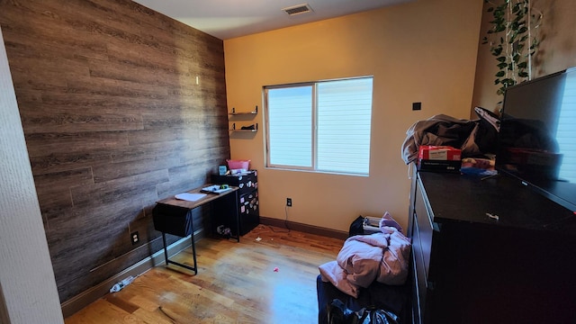 interior space featuring light hardwood / wood-style floors and wood walls