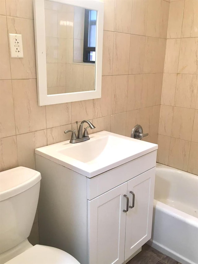 bathroom with tile walls, vanity, decorative backsplash, and toilet