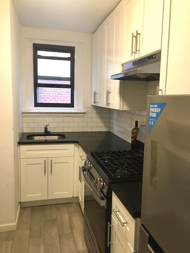 kitchen with backsplash, appliances with stainless steel finishes, sink, and white cabinets