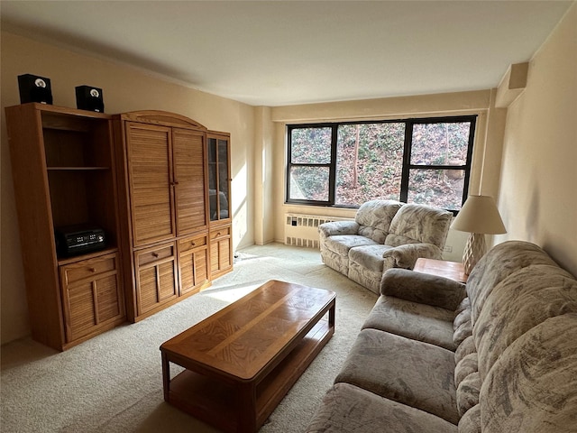 living room with radiator heating unit and light colored carpet