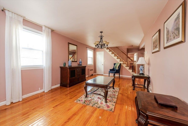 living room featuring a chandelier, a wealth of natural light, radiator, and light wood-type flooring