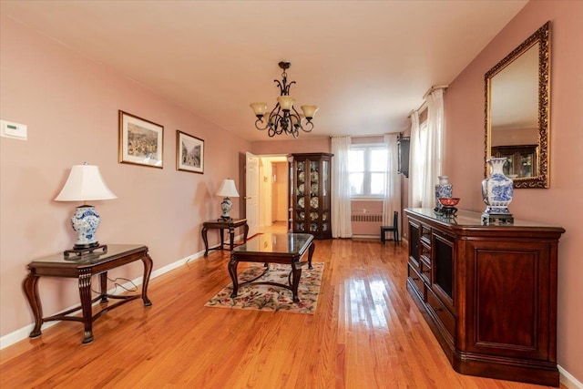 sitting room with an inviting chandelier and light hardwood / wood-style flooring