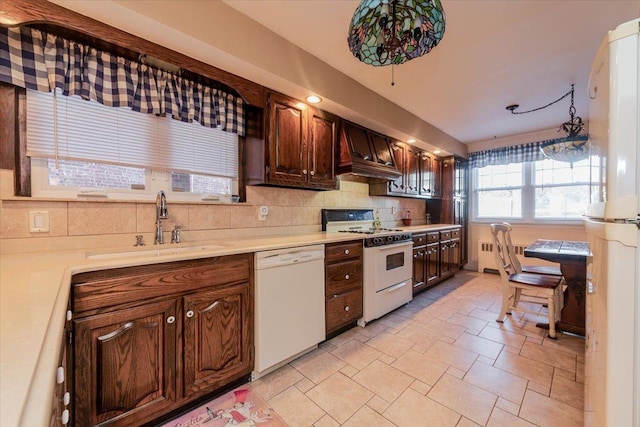 kitchen featuring decorative light fixtures, sink, decorative backsplash, dark brown cabinets, and white appliances