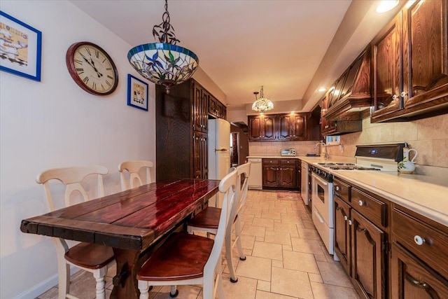 kitchen with pendant lighting, white appliances, premium range hood, and backsplash