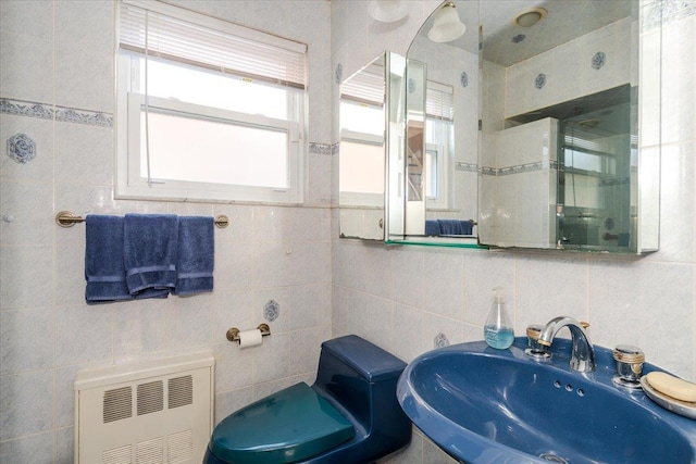 bathroom featuring tile walls, sink, and radiator heating unit