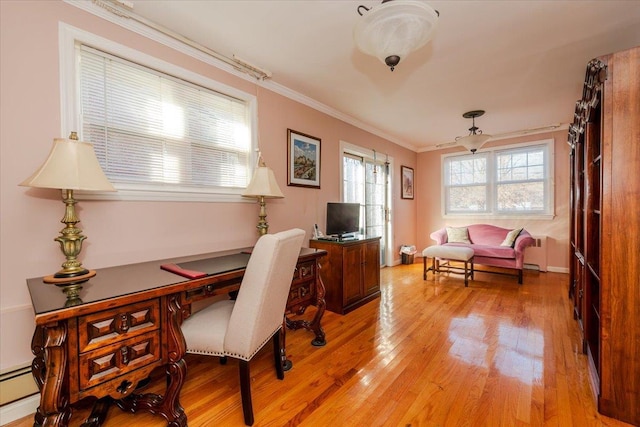 home office with crown molding, a wealth of natural light, baseboard heating, and light hardwood / wood-style flooring