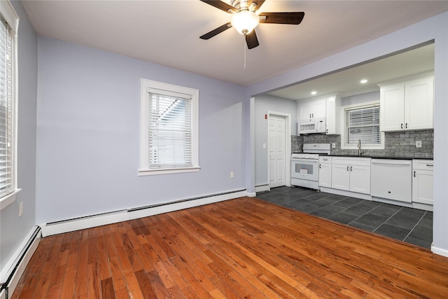 kitchen featuring white appliances, a baseboard radiator, sink, and white cabinets