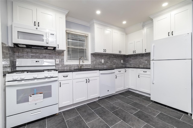 kitchen featuring sink, white cabinetry, dark tile patterned floors, white appliances, and decorative backsplash