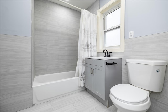 full bathroom with vanity, tile walls, shower / bathtub combination with curtain, and toilet